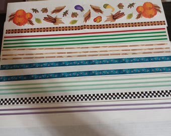 Puede incluir: Una hoja de papel decorativo con varios patrones y diseños, incluyendo un patrón a cuadros, rayas y un patrón con pequeños puntos azules. La parte superior de la hoja presenta una fila de ilustraciones de otoño, incluyendo calabazas, maíz y hojas.