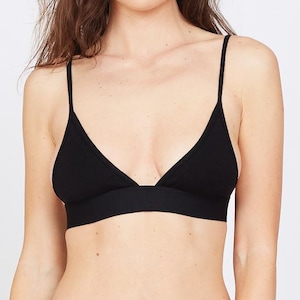 Pode incluir: Um bralette preto com alças finas e um design de taça triangular. O bralette tem uma faixa larga sob o busto e é feito de um material macio e confortável. O bralette faz parte de um conjunto.