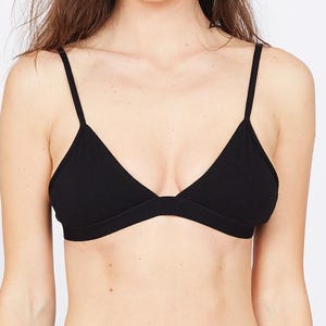 May include: A black triangle bra with thin straps. The bra is made of a soft material and has a simple design. The model is wearing the bra with matching black bottoms. The background is plain white.