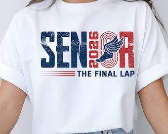 May include: White t-shirt with a distressed design featuring the word "SENIOR" in navy blue, the year "2026" in red, and a winged track shoe graphic. Below, the text reads "THE FINAL LAP" in red. The design is a vintage style.