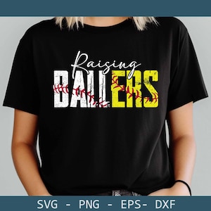 May include: Black t-shirt with the words "Raising Ballers" in white and yellow block letters. The word "Ballers" is in yellow with a softball design. The word "Raising" is in cursive. The shirt is a crew neck.