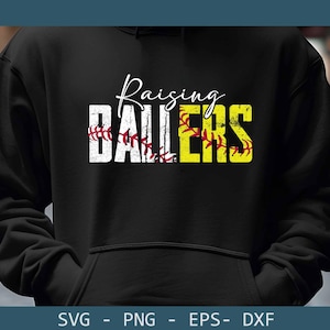 May include: Black hoodie with the words "Raising Ballers" in white and yellow. The word "Ballers" is designed with a softball theme, featuring red stitching. The hoodie is a comfortable apparel item.