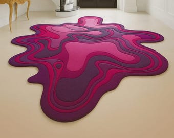 May include: A large, abstract rug in shades of purple and pink. The rug has a layered design, with each layer a different shade of the color family. The rug is placed on a light-colored floor, creating a striking contrast.