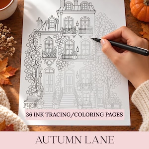 May include: A white sheet of paper featuring a black ink line drawing of a multi-story townhouse with balconies, trees, and pumpkins. The text 36 INK TRACING/COLORING PAGES and AUTUMN LANE is printed on the page. A black pen is held over the drawing.