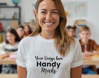 May include: A white t-shirt with rolled-up sleeves featuring the text "Your Design here Handy Mocks" in black. The shirt is worn by a person smiling in a classroom setting, with students and desks visible in the background.