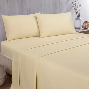 May include: A cream-coloured bed with a fitted sheet and two pillowcases. The bed is made with a soft, smooth fabric.