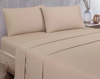 May include: A beige bed with a fitted sheet and two pillowcases. The bed is made with a soft, textured fabric.