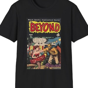 May include: A black t-shirt with a vintage comic book cover featuring a woman in a red dress and a monster with a cape. The comic book cover is titled "The Beyond" and has the text "Weird. Spooky, Supernatural Stories".