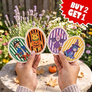 May include: Four oval-shaped stickers featuring Winnie the Pooh characters in Halloween costumes. Tigger as a pirate, Pooh as a pumpkin, Piglet as a bat, and Eeyore as a wizard are depicted on striped backgrounds. A red starburst graphic reads BUY 2 GET 1.