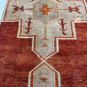May include: A vintage runner rug with a geometric pattern in shades of brown, beige, and white. The rug has a distressed look and is made of a woven material.