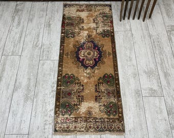 Puede incluir: Una alfombra de pasillo vintage con un patrón floral descolorido en tonos marrones, verdes, rosas y azules. La alfombra tiene un borde con flecos y está hecha de lana.