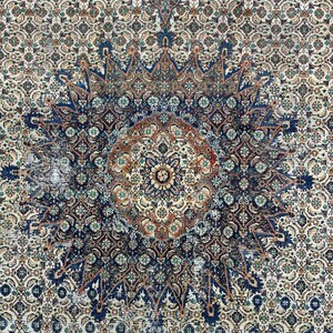 May include: A vintage rug with a blue, brown, and white geometric pattern. The rug has a central medallion with a starburst design.