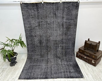 May include: A dark gray vintage rug with a distressed look. The rug has a subtle pattern and is made of a soft, plush material.