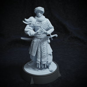 Peut inclure: Une figurine blanche peinte d'une personne portant un turban et des vêtements ornés, tenant une épée. La figurine est debout sur une base ronde.