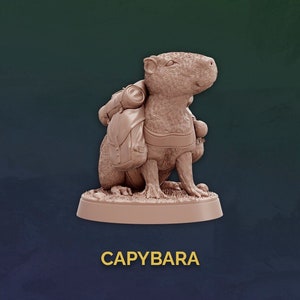 May include: A brown, painted figurine of a capybara wearing a backpack and a belt. The figurine is standing on a round base. The word "CAPYBARA" is written in gold letters below the figurine.
