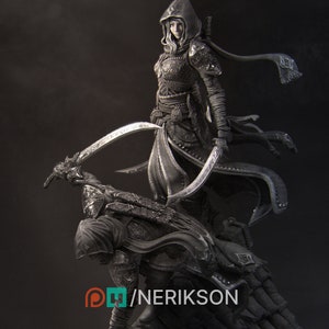 May include: A black and white figurine of a female warrior in a hooded cloak, holding a curved sword. She stands on top of a fallen figure, also in a hooded cloak.