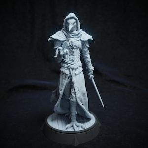 May include: A detailed, light gray figurine of a humanoid figure with a bird-like head, wearing a hooded cloak and holding a sword. The figure is standing on a round base with a wooden floor design. The figure has intricate details.