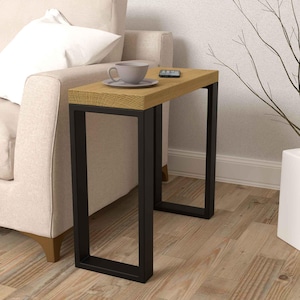 Peut inclure: Une petite table d'appoint en bois avec un cadre en métal noir. La table a un plateau en bois clair et est parfaite pour un salon ou une chambre à coucher.