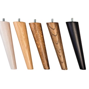 May include: Five wooden furniture legs in different finishes: natural, light wood, dark wood, and black. The legs are tapered and have a metal screw at the top.