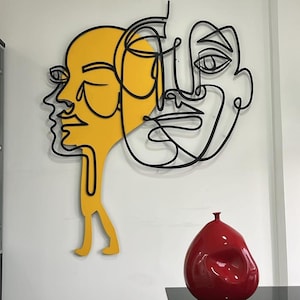 Arte murale minimalista in metallo: scultura di volti astratti