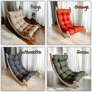 May include: Four rocking chairs with wooden frames and cushioned seats in beige, orange, anthracite, and green. Each chair has a curved base for rocking and a padded backrest. The chairs are displayed in a well-lit room.