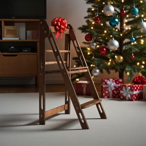 Peut inclure: Un escabeau en bois marron avec un nœud rouge. L'escabeau a trois marches. Un sapin de Noël avec des boules et des lumières est en arrière-plan, ainsi que des cadeaux emballés.