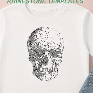 Könnte beinhalten: Ein weißes T-Shirt mit einer schwarzen Totenkopf-Grafik aus kleinen Punkten. Der Text RHINESTONE TEMPLATES ist oben sichtbar, zusammen mit Dateiformat-Symbolen mit der Beschriftung SVG, EPS, PNG, DXF und CDR, die links vertikal angeordnet sind.