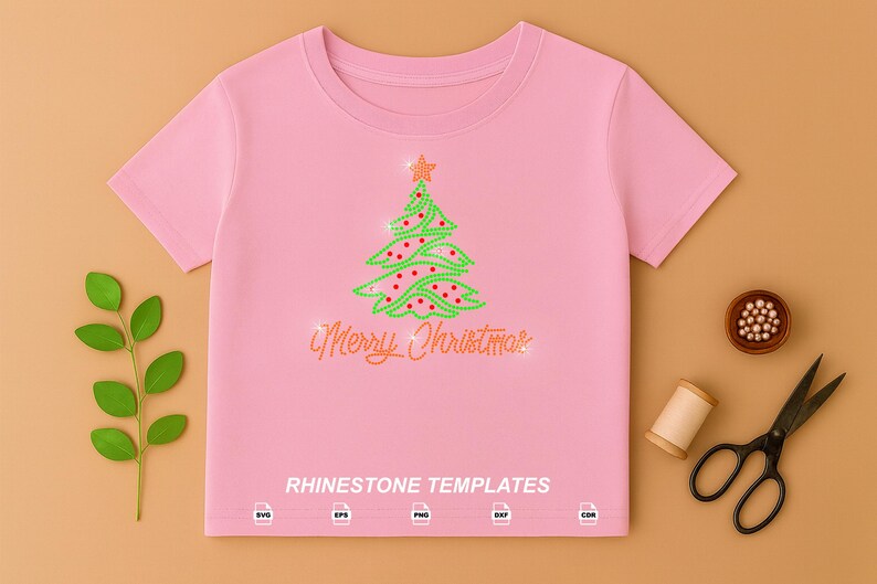 May include: A light pink short-sleeved t-shirt featuring a rhinestone Christmas tree design with a star topper and the text Merry Christmas in script. Below the text, the words RHINESTONE TEMPLATES appear with five file format icons.