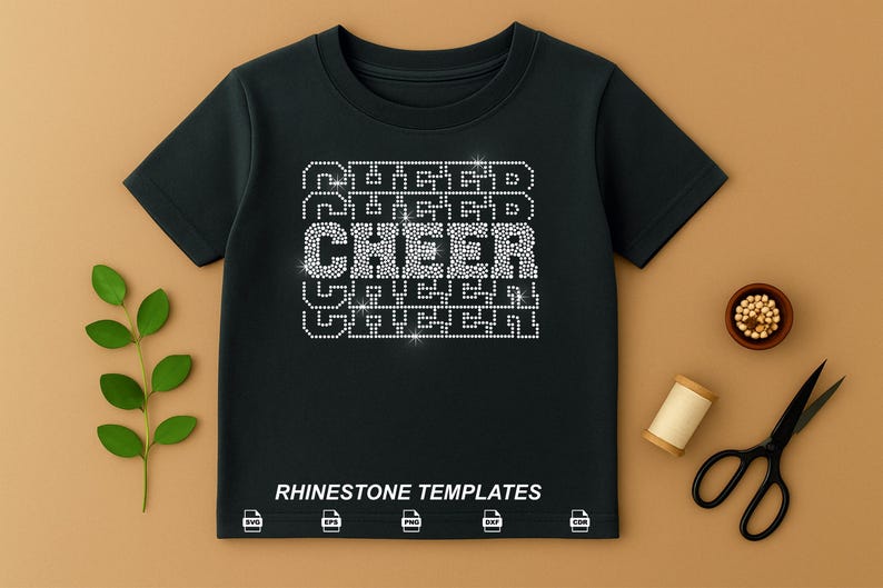 May include: Black t-shirt with the word "CHEER" in rhinestone letters. The word "CHEER" is stacked between the words "RUGGED" and "GREEN". The phrase "RHINESTONE TEMPLATES" is printed at the bottom of the shirt.