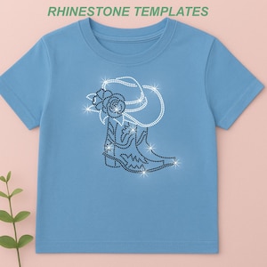 May include: Light blue t-shirt featuring a rhinestone design of a cowboy boot, hat, and rose. The design is made of sparkling rhinestones. The text "RHINESTONE TEMPLATES" is at the top of the image.
