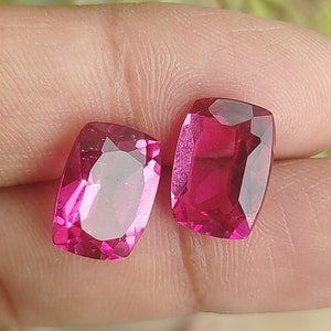 Puede incluir: Dos cabujones de piedra preciosa rosa, cortados en forma rectangular con esquinas redondeadas. Las piedras preciosas están facetadas y tienen un alto pulido.