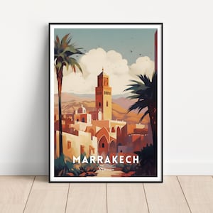 May include: A framed art print featuring a watercolor illustration of Marrakech, Morocco. The artwork depicts a cityscape with a tall minaret, palm trees, and buildings in warm tones of orange, beige, and brown. The word "MARRAKECH" is printed in white.