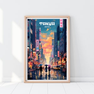 May include: A framed poster with a colorful illustration of a street in Tokyo, Japan. The poster features a sunset sky, tall buildings, and three people walking under umbrellas. The text "TOKYO" and "JAPAN" is printed on the poster.