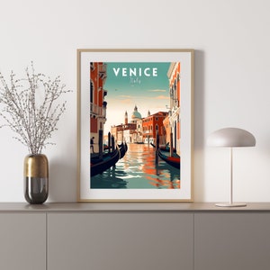Puede incluir: Un cartel de viaje vintage con fondo azul verdoso que muestra una vista de un canal en Venecia, Italia. El cartel tiene el texto "VENICE Italy" en letras blancas. Se pueden ver dos g&oacute;ndolas en el canal, y una iglesia con una c&uacute;pula en la distancia.