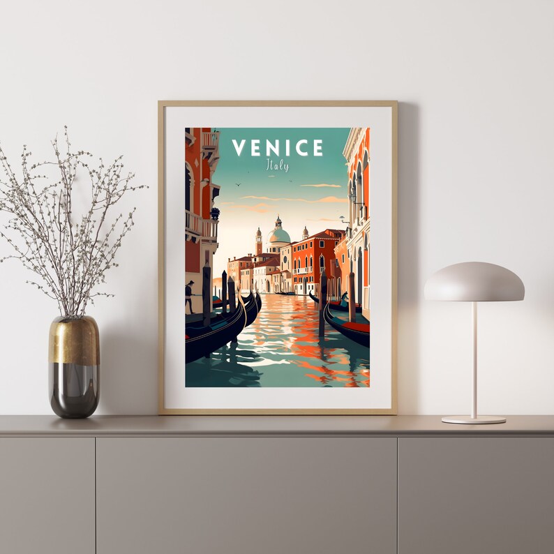 Puede incluir: Un cartel de viaje vintage con fondo azul verdoso que muestra una vista de un canal en Venecia, Italia. El cartel tiene el texto "VENICE Italy" en letras blancas. Se pueden ver dos g&oacute;ndolas en el canal, y una iglesia con una c&uacute;pula en la distancia.