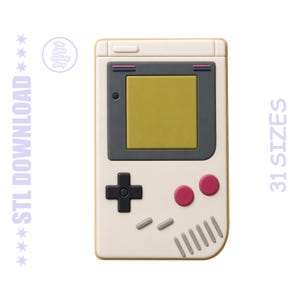 Puede incluir: Una consola de juegos portátil de color crema con una pantalla amarilla, detalles en gris y botones rosas. El dispositivo presenta una cruceta negra y el texto "STL DOWNLOAD" y "31 SIZES".
