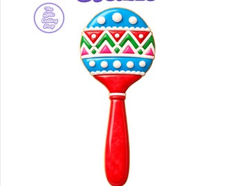 May include: A maraca-shaped cookie cutter design featuring a red handle and a blue, green, and white patterned top. The text 31 SIZES and STL+PNG GUIDE is displayed in purple. A circular logo reads The Little Cutting Shop in the upper left corner.
