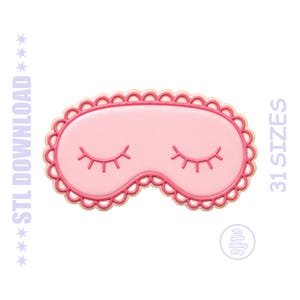 Puede incluir: Un cortador de galletas con forma de antifaz para dormir de color rosa con borde festoneado y detalles de ojos cerrados. El texto STL DOWNLOAD y 31 SIZES es visible a los lados, con un pequeño logo circular The Little Cutting Shop abajo.