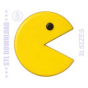 Puede incluir: Un cortador de galletas Pac-Man amarillo con un ojo negro y la boca abierta. El cortador de galletas es un diseño clásico de personaje de videojuego. El texto "STL DOWNLOAD" y "31 SIZES" son visibles en los lados izquierdo y derecho de la imagen.
