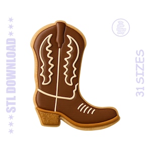 May include: A brown cowboy boot-shaped cookie with white decorative icing. The cookie has a tan border and a detailed design, including a heel and stitching. The image also includes the text "STL DOWNLOAD" and "31 SIZES".
