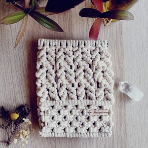 Op de afbeelding: Een beige macramé tasje met een bruin leren label waarop "Moon Spirit Co." staat.