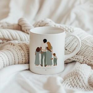 May include: White ceramic mug with a graphic of a family of five standing together. The family is made up of two adults and three children. The adults are holding hands with the children. The mug has the names "Suzanne, Yann, Laur&egrave;ne, Jade" written on the bottom.