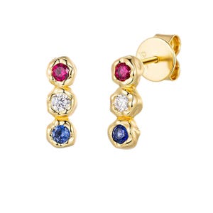 Pode incluir: Brincos de ouro com três pedras preciosas: um rubi vermelho, um diamante branco e um safira azul. As pedras preciosas são engastadas em uma moldura de ouro texturizada.