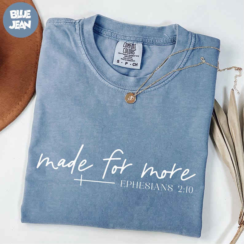 A blue t-shirt with the text "made for more" printed on it, along with a small Bible verse reference.