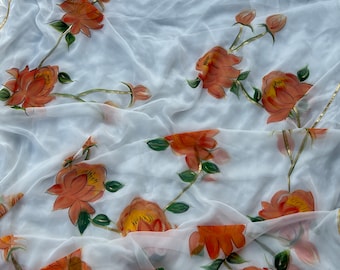 Può includere: Tessuto bianco trasparente con disegni floreali arancioni dipinti a mano. Il tessuto è traslucido e i fiori sono dettagliati con foglie verdi e accenti dorati.