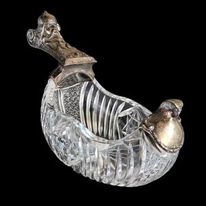 Op de afbeelding: Een witte keramische mok met een zwart handvat en de tekst "But First, Coffee" in een vetgedrukte, zwarte letter. De mok staat op een houten oppervlak. De mok is ongeveer 10 cm hoog.