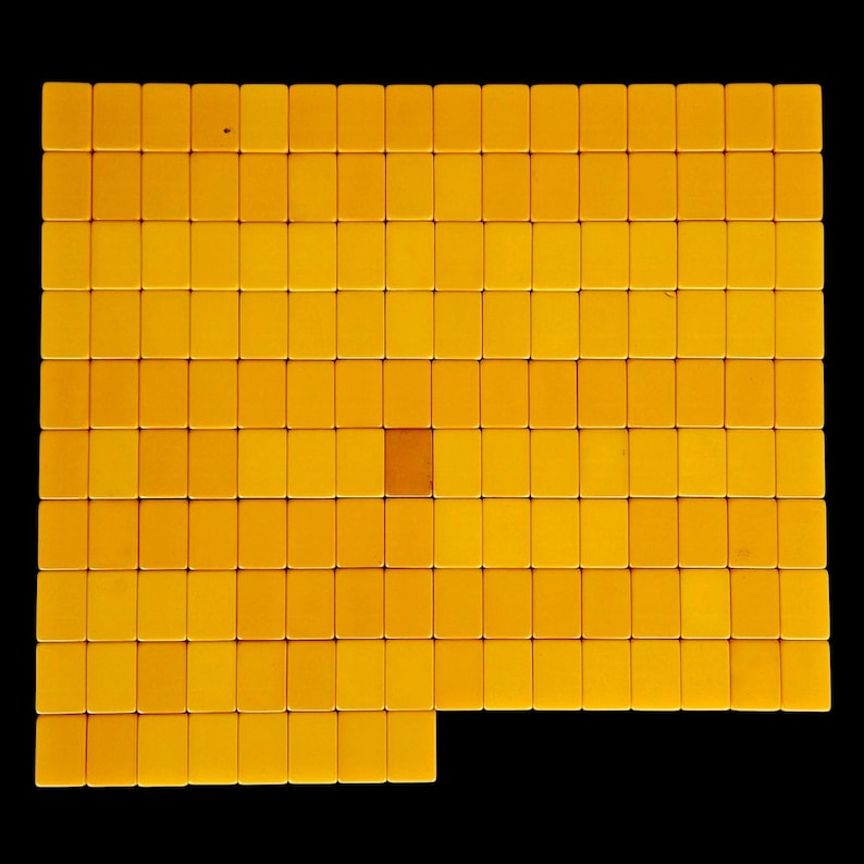 May include: A grid of rectangular yellow tiles arranged in a large square formation. The tiles are uniform in size and color, except for one single tile in the center which is a darker shade of orange. The tiles are laid out in rows and columns.