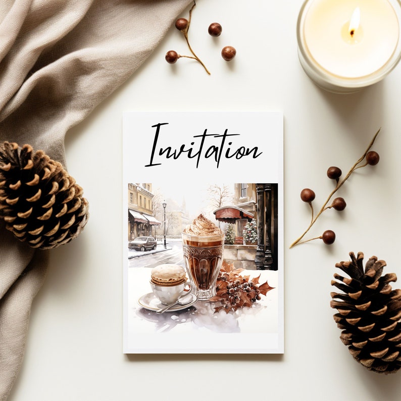 May include: A white card with the word "Invitation" printed in black at the top. The card features a watercolor illustration of a cup of hot chocolate with whipped cream and a small pastry on a plate. The illustration is set against a backdrop of a city street scene.