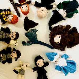 Könnte beinhalten: Eine Sammlung handgefertigter Harry-Potter-Charaktere aus Häkelgarn, darunter Harry Potter, Hermine Granger, Ron Weasley, Draco Malfoy, Albus Dumbledore, Severus Snape, Hagrid und Dobby. Die Charaktere tragen alle ihre charakteristischen Kleidungsstücke und Accessoires.