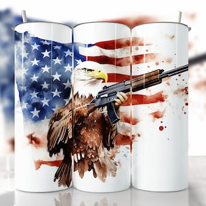May include: A white tumbler with a watercolour design of an American flag and a bald eagle holding a rifle.